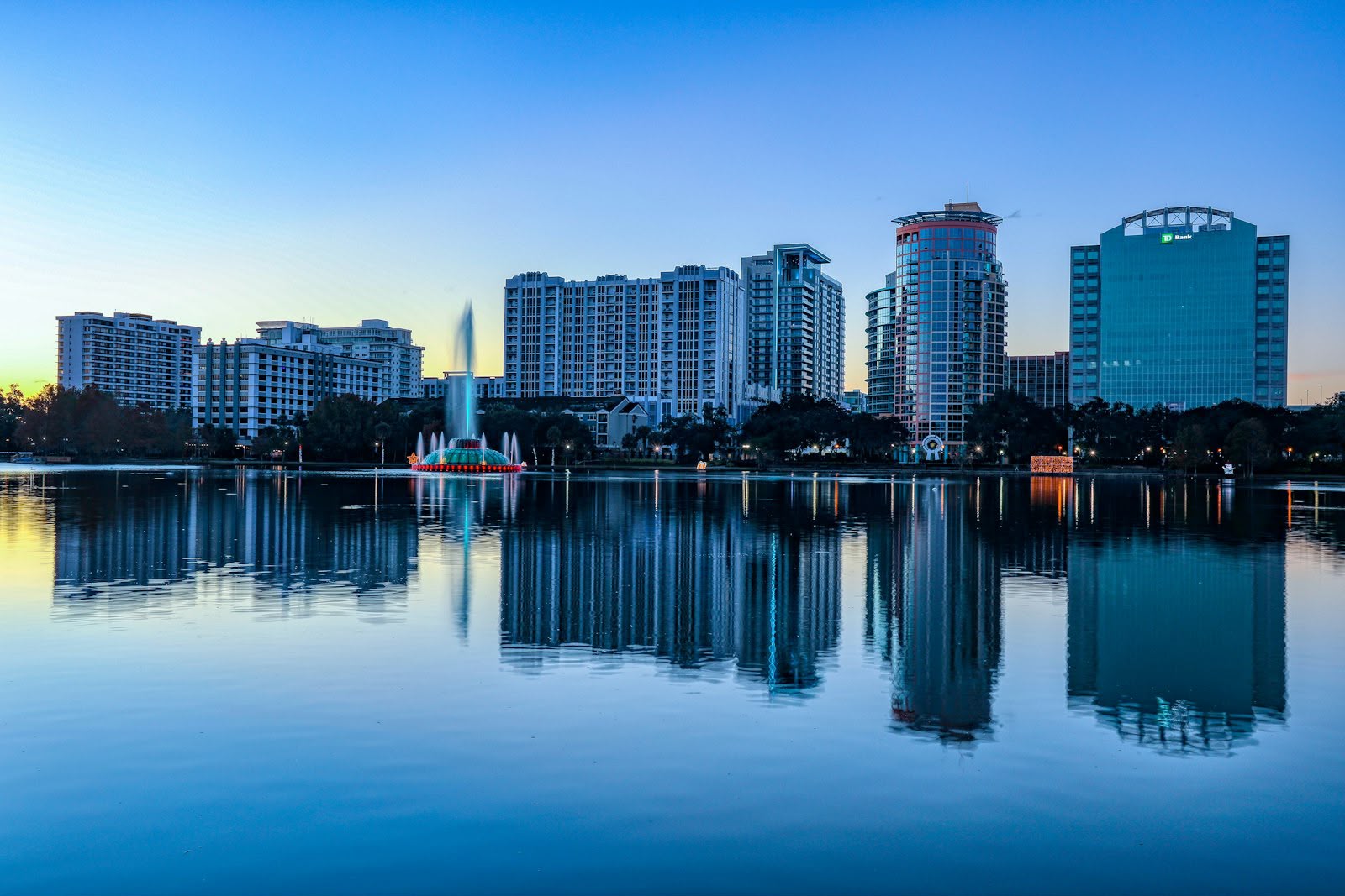 The Orlando skyline at blue hour, reflected in the still water of Lake Eola